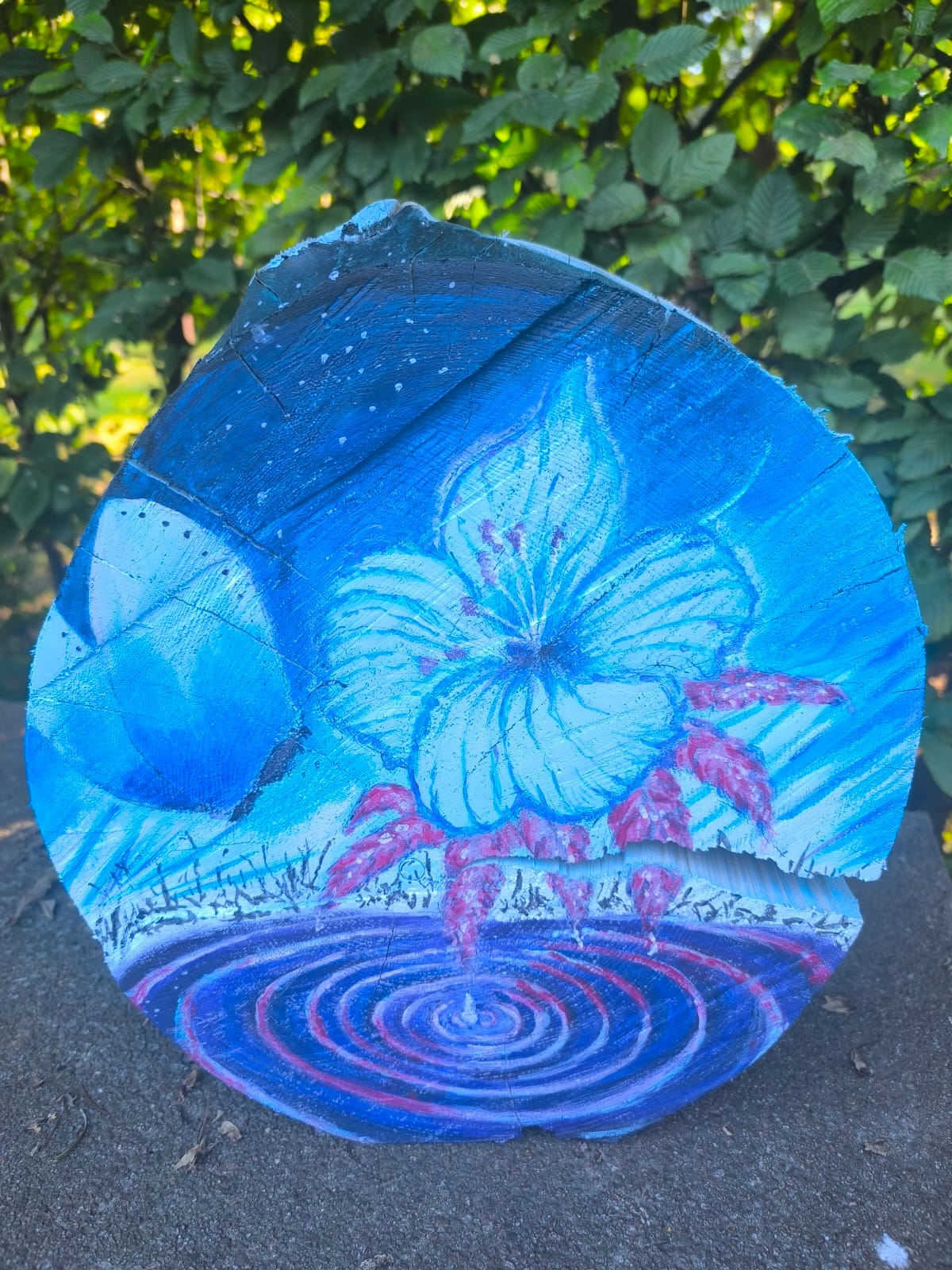 Bemalte Baumscheibe mit Hibiskusblüte und Mondmotiv in Blautönen